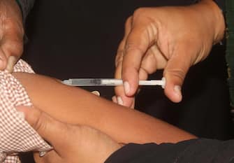 A health worker administers a dose of a vaccine to school children during an inoculation drive of a measles and rubella prevention campaign in Hyderabad, Pakistan, 15 November 2021. According to health officials, thousands of children under 15 years of age will be vaccinated against Measles and Rubella virus at different EPI centres through the schools vaccination campaign. ANSA/NADEEM KHAWAR