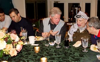 DCA99 - 20000716 - THURMONT, UNITED STATES : This official White House photo released 16 July 2000 shows US President Bill Clinton (C) hosting Israeli Prime Minister Ehud Barak (2nd L) and Palestinian Chairman Yassar Arafat (2nd R) at a working dinner at Camp David during the Middle East Peace Summit, 15 July 2000. Negotiations were set to intensify 16 July on the summit's sixth day. At far left is Mohamad Dahlan and at right is Gamal Helal.  
EPA PHOTO AFP/THE WHITE HOUSE/SHARON FARMER/rg/jl