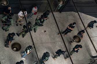 HONG KONG, CHINA - JULY 04: Riot police stop and search people as they celebrate the declaration of Independence of the United States outside the US Consulate General on July 4, 2020 in Hong Kong, China. Hong Kong marked the 23rd anniversary of the handover of the former British colony to China on July 1 hours after Beijing imposed the new national security law.  (Photo by Anthony Kwan/Getty Images)