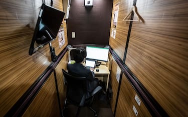 TOKYO, JAPAN - DECEMBER 17: A staff member illustrates working at a coworking space at the hotel Anshin Oyado on December 17, 2020 in Tokyo, Japan. The hotel Anshin Oyado renovated its capsule style hotel room into coworking space due to a financial blow caused by the COVID-19 coronavirus pandemic. (Photo by Yuichi Yamazaki/Getty Images)