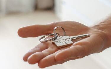 Young single man tenant renter first time home owner holding key to new apartment on hand. Male house buyer customer moving into own flat, buy real estate mortgage investment purchase concept. Closeup