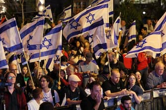 Demonstrators lift flags during a rally in Tel Aviv to protest the Israeli government's judicial overhaul bill, as the country begins celebrations for its 75th anniversary, on April 25, 2023. (Photo by JACK GUEZ / AFP) (Photo by JACK GUEZ/AFP via Getty Images)