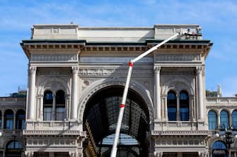 Lavori di pulizia dei graffiti sul frontone della Galleria Vittorio Emanuele II a Milano, 9 agosto 2023. ANSA/MOURAD BALTI TOUATI