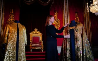 LONDON, ENGLAND - MAY 01:  Caroline de Guitaut, deputy surveyor of the King's Works of Art for the Royal Collection Trust, adjusts the Imperial Mantle, which forms part of the Coronation Vestments, displayed in the Throne Room at Buckingham Palace on May 1, 2023 in London, England. The vestments will be worn by King Charles III during his coronation at Westminster Abbey on May 6. (Photo by Victoria Jones-Pool/Getty Images)