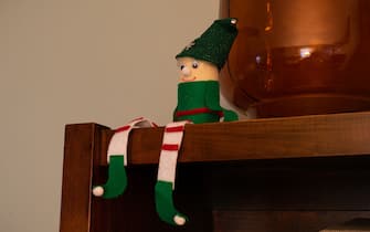 Elf decoration on top of bookshelf.