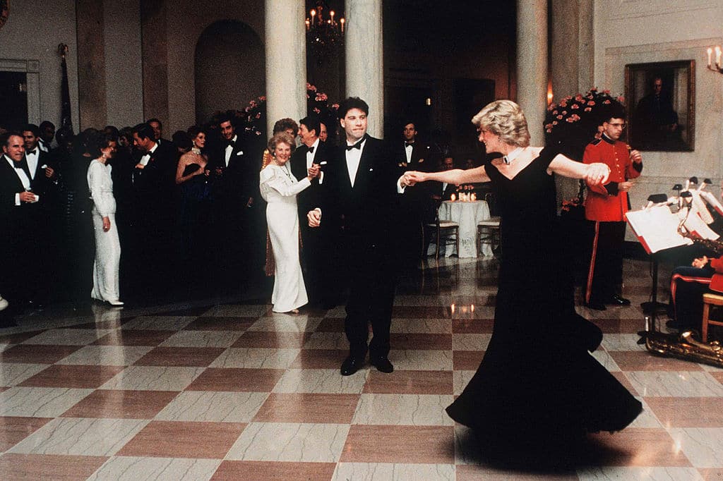 WASHINGTON, DC - NOVEMBER 09: Diana, Princess Of Wales, wearing a midnight blue velvet, off the shoulder evening gown designed by Victor Edelstein, is watched by US President Ronald Reagan and First Lady Nancy Reagan, as she dances with John Travolta at the White House on November 9, 1985 in Washington, DC. (Photo by Anwar Hussein/ WireImage)