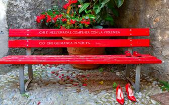 red bench with shoes symbol against violence against women cervo italy