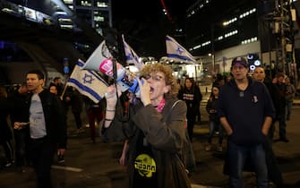 A woman speaks in a megaphone during a rally of relatives and supporters calling for the release of Israeli hostages held in Gaza since the October 7 attacks by Hamas in southern Israel, in Tel Aviv on January 20, 2024. (Photo by AHMAD GHARABLI / AFP)