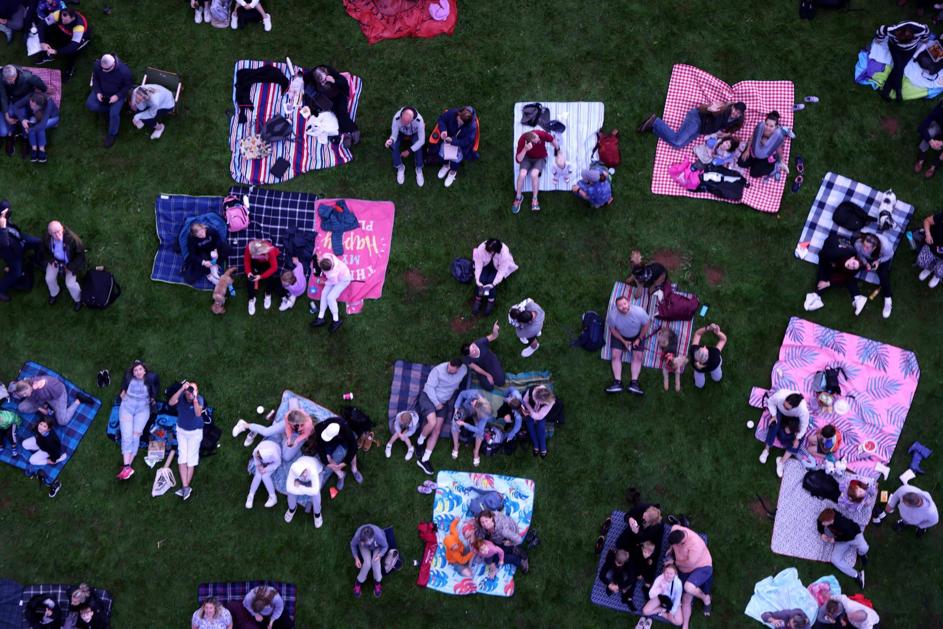 epa10794766 A crowd watches hot air balloons take part in a mass ascent during the Bristol International Balloon Fiesta in Bristol, Britain, 11 August 2023. The four-day event has over 100 hot air balloons expected to participate and runs from 10 to 13 August 2023.  EPA/NEIL HALL