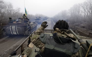 TOPSHOT - A convoy of Ukrainian forces drives to Debaltseve, Donetsk region, on February 14, 2015. Fighting has raged on in Ukraine, throwing doubts on a ceasefire deal due to take effect over the weekend, with the US saying Russia is still deploying heavy arms and Kiev warning that shelling of civilians had intensified.AFP PHOTO/ ANATOLII STEPANOV (Photo by ANATOLII STEPANOV / AFP) (Photo by ANATOLII STEPANOV/AFP via Getty Images)