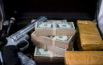 Gun with bullets lying on the table. Criminal problems. Drugs and money on black background. Illegal selling.