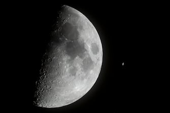epa10550002 The International Space Station (ISS) passes in front of the Moon as captured near Buzitka, southern Slovakia, 29 March 2023 (issued 30 March 2023).  EPA/Peter Komka HUNGARY OUT