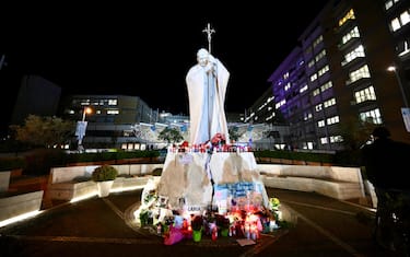 Flowers and candles lay at the foot of a statue of Pope St. John Paul II outside the Gemelli Hospital in Rome, Italy, 27 February 2025, where Pope Francis is hospitalized for tests and treatment for bronchitis. Pope Francis was hospitalized on 14 February 2025 due to a respiratory tract infection. ANSA/ALESSANDRO DI MEO