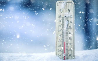 Thermometer on snow shows low temperatures - zero. Low temperatures in degrees Celsius and fahrenheit. Cold winter weather - zero celsius thirty two f