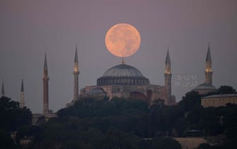 The Sturgeon super moon rises over the Ayasofya-i Kebir Camii or Hagia Sophia Grand Mosque in Istanbul on August 2, 2023. (Photo by YASIN AKGUL / AFP) (Photo by YASIN AKGUL/AFP via Getty Images)