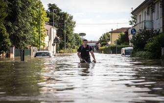 "Un ragazzo in bicicletta nel mezzo dell'acqua alta" "Lugo/ 18 mag 2023" ANSA/MAX CAVALLARI