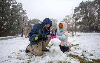 Glendale, CA - February 25: Father Brendan Prouty, 42, left, and his daughter Charlotte Prouty, 7, right, build a snowman in Dunsmore Park on Saturday afternoon, Feb. 25, 2023, in Glendale, CA. A historic winter storm slamming California with heavy rains, dangerous winds and rare snowfall intensified Friday as it moved south, shutting down mountain freeways and prompting severe weather warnings not often seen in the region. (Francine Orr / Los Angeles Times via Getty Images)