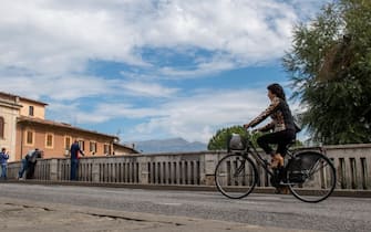 A lady crosses the Ponte Romano bridge on a bicycle, on a beautiful late October day, in Rieti, Italy, on 9 October 2022.  (Photo by Riccardo Fabi/NurPhoto via Getty Images)