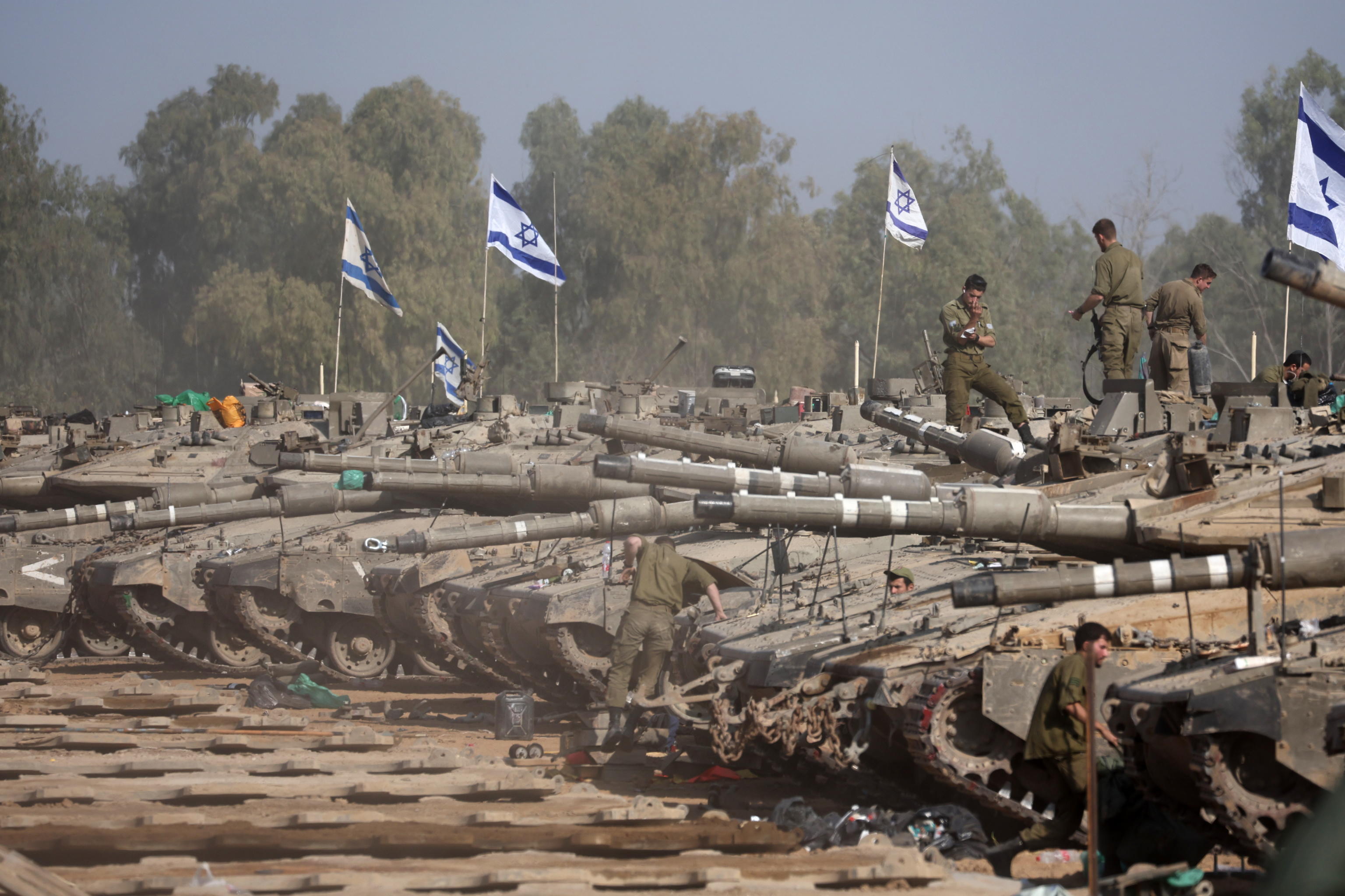 epaselect epa11052117 Israeli soldiers with their tanks gather at a position near the border with the Gaza Strip, in southern Israel, 01 January 2024. More than 21,600 Palestinians and at least 1,300 Israelis have been killed, according to the Palestinian Health Ministry and the Israel Defense Forces (IDF), since Hamas militants launched an attack against Israel from the Gaza Strip on 07 October, and the Israeli operations in Gaza and the West Bank which followed it. The Israeli military stated that its ground, air, and naval troops are 'continuing to conduct joint combat' across the Gaza Strip.  EPA/ABIR SULTAN