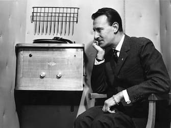 Italian TV and radio presenter Nunzio Filogamo sitting beside a record player. 1950s. (Photo by Mondadori via Getty Images)