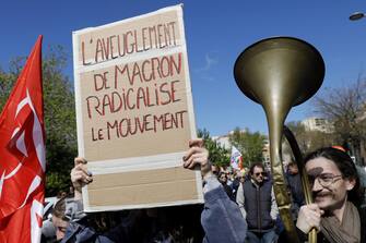 epa10570628 A placard reads 'Macron's blindness radicalized the movement' as people attend a rally against the government's reform to the pension system in Montpellier, France, 13 April 2023. The 'sages', members of the Constitutional Council, are due to deliver their verdict on 14 April concerning the examination of the text of the pension reform, almost one month after the country's prime minister announced the use of article 49.3 of the French Constitution to have the text of the controversial bill to be definitively adopted without a vote. The reform would raise the retirement age in France from 62 to 64.  EPA/Guillaume Horcajuelo