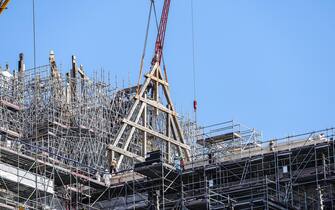 epa10739070 Operators receive the first wood framework at the construction site of Notre Dame Cathedral in Paris, France, 11 July 2023. The oak trusses of the framework are 14 to 16 metres wide and 12 to 13 metres high and weigh between 7 and 7.5 tons, and are the main framework for the Cathedral's spire. Since the fire which devastated the cathedral on 15 April 2019, hundreds of people are working on its reconstruction with the target to reopen the Cathedral before the end of 2024.  EPA/TERESA SUAREZ