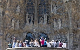 epaselect epa05906142 Tourists look up the Charity's Gate as they take the opportunity to visit the Sagrada Famila Cathedral on Maundy Thursday (Holy Thursday) in Barcelona, northeastern Spain, 13 April 2017.  EPA/QUIQUE GARCÍA