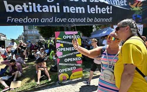 Participants pose for a selfie as they arrive to take part in the Budapest Pride march, on June 28, 2025 in Budapest, despite a governmental ban of the event. Hungary's Prime Minister had announced that police will not "break up" Saturday's Budapest Pride march despite issuing a ban, but warned attendees and organisers about the legal consequences. His ruling coalition amended laws and the constitution earlier this year to prohibit the annual celebration, advancing his widely condemned, years-long clampdown on LGBTQ rights in the name of "child protection". (Photo by Attila KISBENEDEK / AFP)
