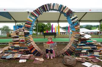 HAY-ON-WYE, WALES - MAY 28:  Maeve Magee, 3, reads a book during the Hay Festival on May 28, 2014 in Hay-on-Wye, Wales. The Hay Festival is an annual festival of literature and arts which began in 1988.  (Photo by Matthew Horwood/Getty Images)