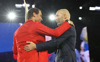 TOPSHOT - Paris 2024 Olympics - Opening Ceremony - Paris, France - July 26, 2024. Torchbearer Zinedine Zidane passes the Olympic torch to Rafael Nadal of Spain during the opening ceremony. (Photo by Stephanie Lecocq / POOL / AFP) (Photo by STEPHANIE LECOCQ/POOL/AFP via Getty Images)