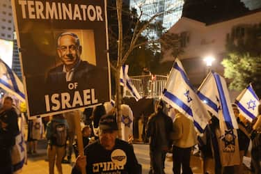 An Israeli carries a poster representing Prime Minister Benjamin Netanyahu during a demonstration against the government's controversial justice reform bill in Tel Aviv on March 4, 2023. (Photo by JACK GUEZ / AFP) (Photo by JACK GUEZ/AFP via Getty Images)