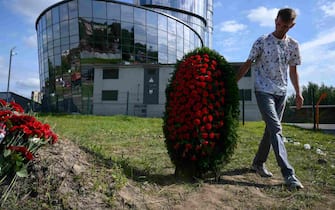 epa10817449 A man carries a wreath at an informal memorial next to the former 'PMC Wagner Centre' in St. Petersburg, Russia, 24 August 2023. An investigation was launched into the crash of an aircraft in the Tver region in Russia on 23 August 2023, the Russian Federal Air Transport Agency said in a statement. Among the passengers was Wagner chief Yevgeny Prigozhin, the agency reported.  EPA/ANTON MATROSOV