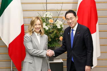 Italy's Prime Minister Giorgia Meloni (L) shakes hands with Japan's Prime Minister Fumio Kishida during their meeting at the prime minister's office in Tokyo on February 5, 2024. (Photo by Rodrigo Reyes Marin / POOL / AFP) (Photo by RODRIGO REYES MARIN/POOL/AFP via Getty Images)