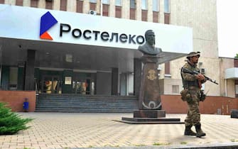 epa10709151 A serviceman from private military company (PMC) Wagner Group blocks the access to the Rostelecom building in Rostov-on-Don, southern Russia, 24 June 2023. Security and armoured vehicles were deployed after Wagner Group's chief Yevgeny Prigozhin said in a video that his troops had occupied the building of the headquarters of the Southern Military District, demanding a meeting with Russia s defense chiefs.  EPA/ARKADY BUDNITSKY