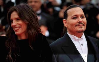 US actor Johnny Depp (R) arrives with French actress and director Maiwenn for the opening ceremony and the screening of the film "Jeanne du Barry" during the 76th edition of the Cannes Film Festival in Cannes, southern France, on May 16, 2023. (Photo by Valery HACHE / AFP) (Photo by VALERY HACHE/AFP via Getty Images)