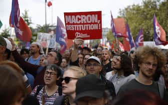 epa11591122 People attend a protest rally in Paris, France, 07 September 2024 as the French left parties called for rallies against President Macron's politics. Protests are taking place across France over the appointment of Michel Barnier as the new French prime minister, after the election that resulted in a National Assembly without a majority and in which the left won the largest number of seats. The poster reads "Macron destitution''.  EPA/YOAN VALAT