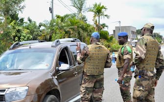 epa10828741 Members of the security forces gesture to a driver, at a checkpoint in the streets of Akanda, Gabon, 30 August 2023. Members of the Gabonese army on 30 August announced on national television that they were canceling the election results and putting an end to Gabonese President Ali Bongo's regime, who had been declared the winner.  EPA/STR