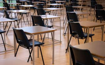 School chairs and tables set up for exams in a school hall. Early morning preparation for examinations in an exam room