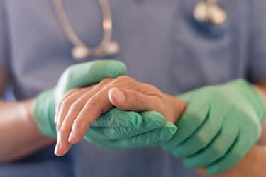 Surgeon, physician performs surgical operations, anesthetist or anesthesiologist holding patient's hand ffor checking state of mand or support in ER room, Medical healthcare concept