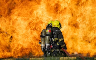 Firemen,Fireman using water and extinguisher to fighting with fire flame in an emergency situation,firefighter training.