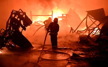 TOPSHOT - Ukrainian firefighters work to extinguish a fire at the site of a drone attack on industrial facilities in Kharkiv on May 4, 2024, amid the Russian invasion of Ukraine. (Photo by SERGEY BOBOK / AFP) (Photo by SERGEY BOBOK/AFP via Getty Images)