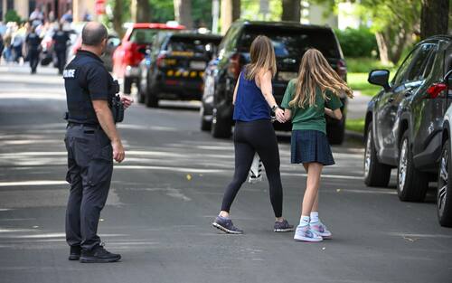 epa12327137 An adult and child comfort each other as the leave the school as police respond to a shooting at the Annunciation Catholic School in Minneapolis, Minnesota, USA, 27 August 2025. According to police, two children and the gunman died and several were injured in the shooting at a Catholic primary church.  EPA/CRAIG LASSIG