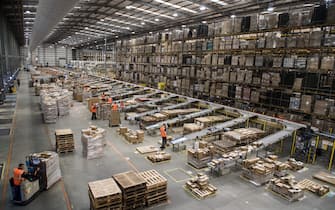 Workers prepare customer orders for dispatch as they work around goods stored inside an Amazon.co.uk fulfillment centre in Peterborough, central England, on November 15, 2017. - Shops could be seeing the effect of consumers postponing purchases until "Black Friday" on November 24, 2017, a day of sales in the United States that has become increasingly popular in Britain. (Photo by CHRIS J RATCLIFFE / AFP)        (Photo credit should read CHRIS J RATCLIFFE/AFP via Getty Images)