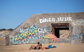 Tourists enjoy on the beach of "Plage de la Conche" next to a former German bunker, a defensive military fortification used in World War II, on the August 9, 2012 near Saint-Clement-des-Baleines on the Re island.   AFP PHOTO/JOEL SAGET (Photo by Joël SAGET / AFP) (Photo by JOEL SAGET/AFP via Getty Images)