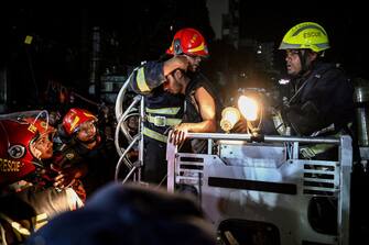 Firefighters use a fire ladder to extract victims during rescue operations following a fire in a commercial building that killed at least 43 people, in Dhaka, on February 29, 2024. At least 43 people were killed and dozens injured after a fire blazed through a seven-storey building in an upscale neighbourhood in the Bangladeshi capital of Dhaka late on February 29, health authorities said. (Photo by Munir Uz Zaman / AFP) (Photo by MUNIR UZ ZAMAN/AFP via Getty Images)