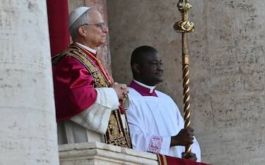 Newly elected Pope Robert Francis Prevost, Pope Leo XIV, (L) arrives on the main central loggia balcony of the St Peter's Basilica for the first time, after the cardinals ended the conclave, in The Vatican, on May 8, 2025. Robert Francis Prevost was on Thursday elected the first pope from the United States, the Vatican announced. A moderate who was close to Pope Francis and spent years as a missionary in Peru, he becomes the Catholic Church's 267th pontiff, taking the papal name Leo XIV. (Photo by Andrej ISAKOVIC / AFP)