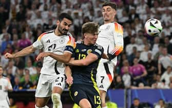 Scotland's defender #13 Jack Hendry (C) fights for the ball with Germany's midfielder #21 Ilkay Gundogan (L) and Germany's forward #07 Kai Havertz during the UEFA Euro 2024 Group A football match between Germany and Scotland at the Munich Football Arena in Munich on June 14, 2024. (Photo by Miguel MEDINA / AFP)