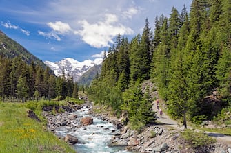 Hikers walking in the Gran Paradiso National Park or Parco nazionale del Gran Paradiso, with a view up the Torrente Valnontey to mountains. (Photo by: Ken Welsh/Education Images/Universal Images Group via Getty Images)
