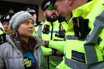 TOPSHOT - A police officer speaks to Swedish climate activist Greta Thunberg moments before she was arrested outside the InterContinental London Park Lane during the "Oily Money Out" demonstration organised by Fossil Free London and Greenpeace on the sidelines of the opening day of the Energy Intelligence Forum 2023 in London on October 17, 2023. (Photo by HENRY NICHOLLS / AFP) (Photo by HENRY NICHOLLS/AFP via Getty Images)