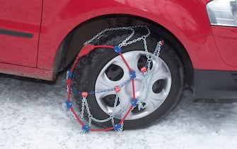 putting on snow chains on a car